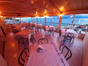 Εστιατόριο Mitho View με θέα θάλασσα και τραπέζια στρωμένα το βράδυ στην Αιδηψό