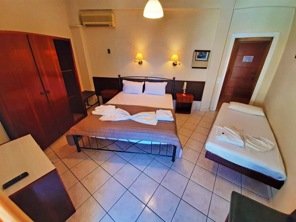 Ευρύχωρο τρίκλινο δωμάτιο με διπλό κρεβάτι, ψυγείο και TV στο Mitho Hotel Spa